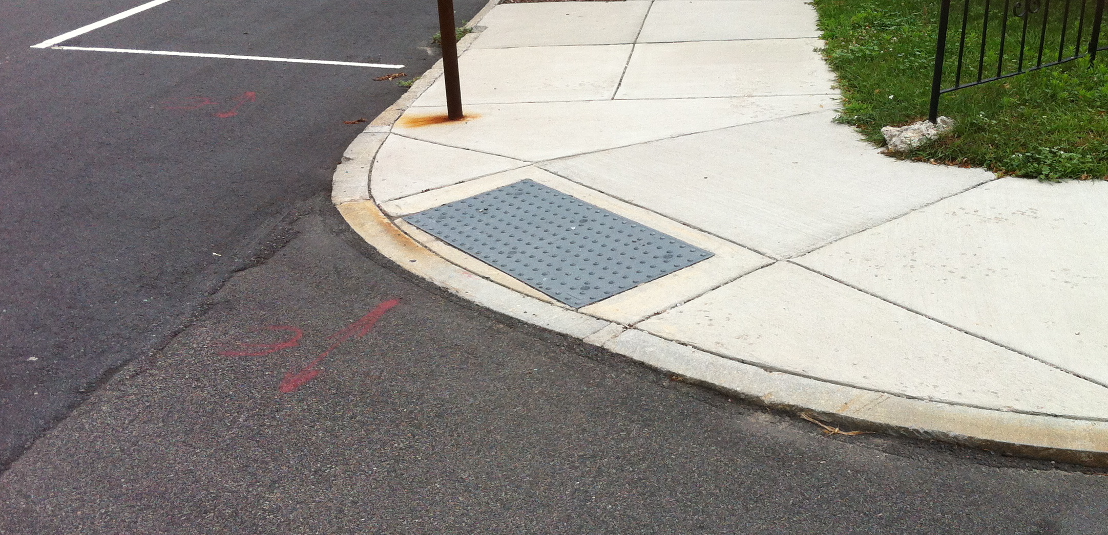 a generic looking curb cut. it&rsquo;s a wedge cut into the sidewalk to allow wheelshairs to move between the sidewalk and street at an intersection
